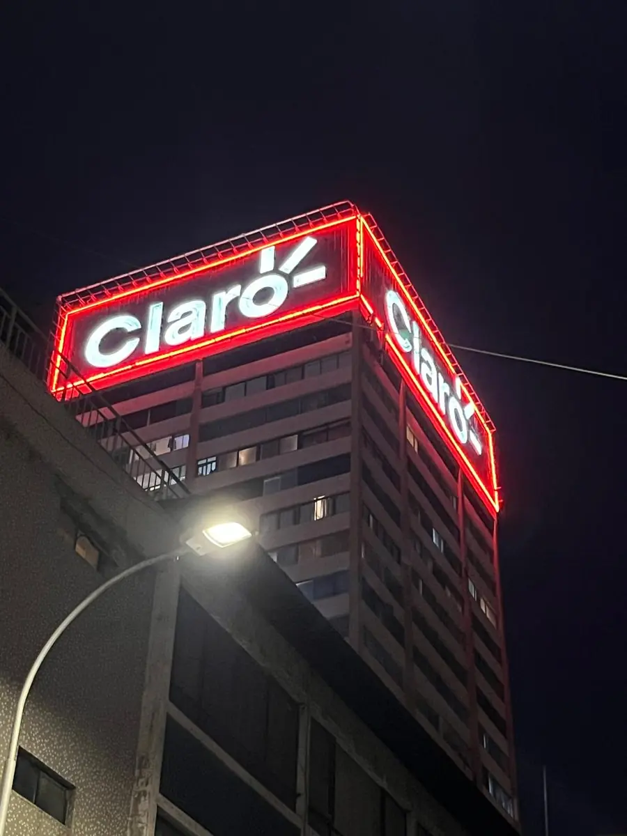 Letrero corporativo iluminado en la esquina superior de un edificio