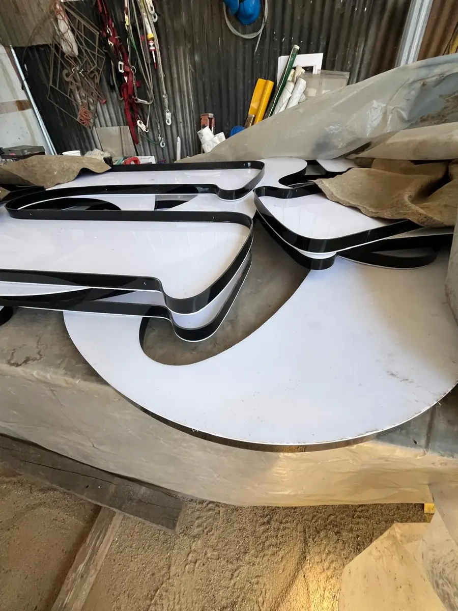 Letras corpóreas terminadas en blanco y negro listas en el taller